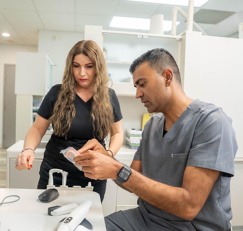 Dr. Jignesh Patel works with a female staff member at the Dental Center of Jacksonville, FL
