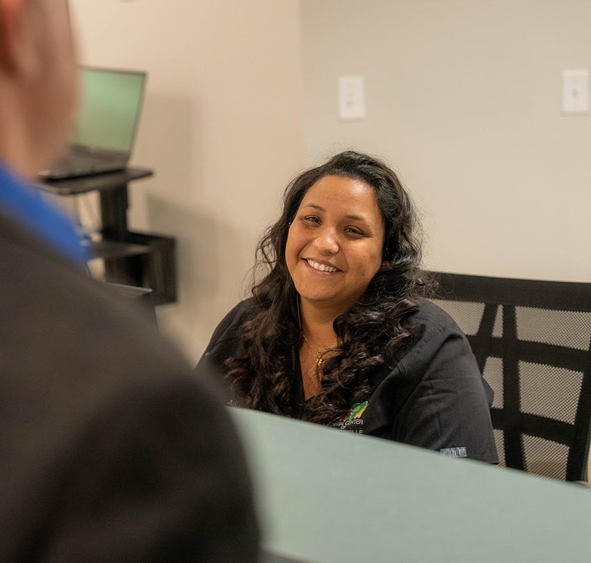 The reception staff smiles at a guest in the Dental Center of Jacksonville, FL