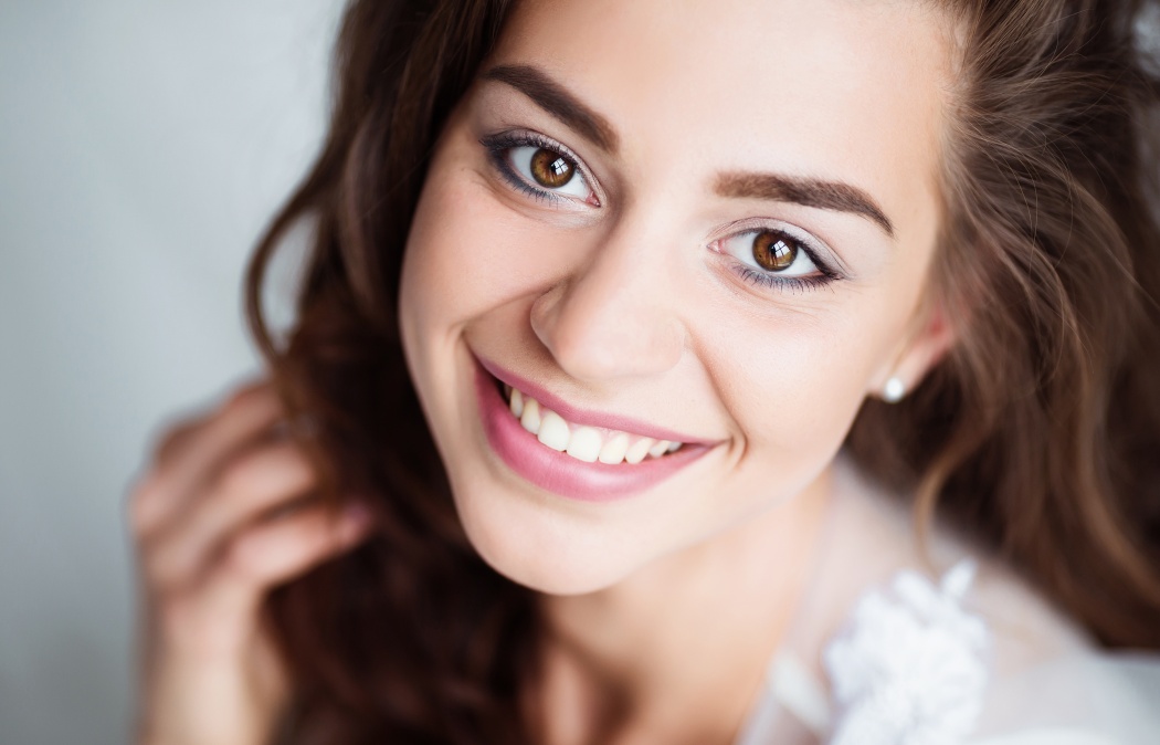 Portrait of smiling woman with perfect smile and white teeth looking at camera.
