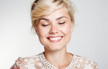 Lovely young woman smiling . Happy blond young woman smiling studio