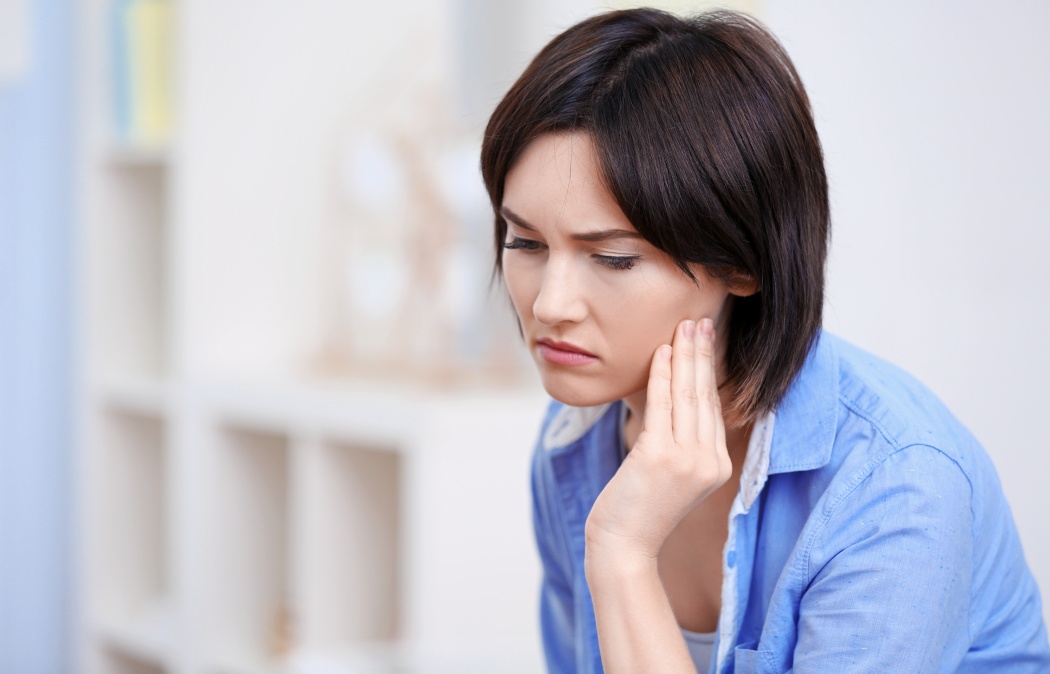 Beautiful young woman suffering from toothache at home
