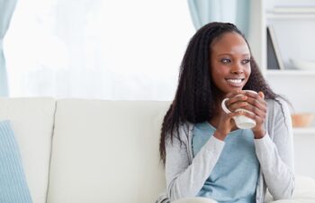 Smiling woman with a cup on couch