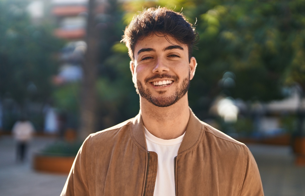 Young hispanic man smiling confident standing at park