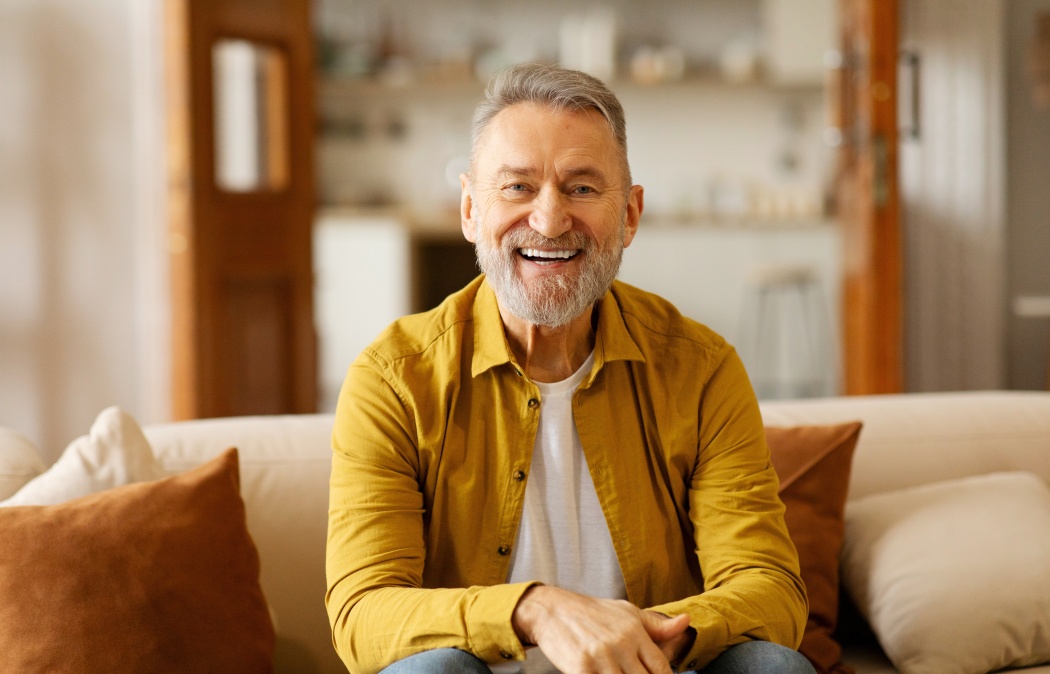 Portrait of happy older retired man laughing, looking at camera, enjoying video call or distant communicating with friends
